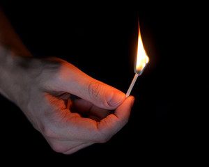 adult man hand holding matchstick