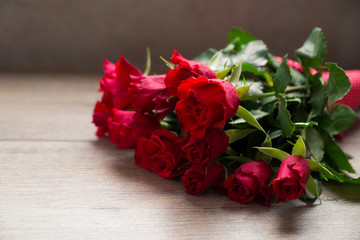 Strauß roter Rosen auf Holzuntergrund