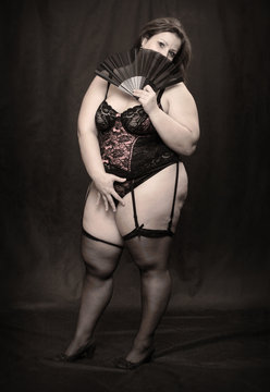 Retro style picture of an overweight woman dressed in corset.