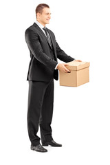 Smiling businessman in suit giving a box to someone