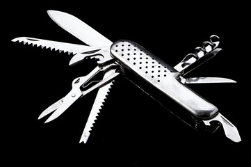 Swiss knife on the black background