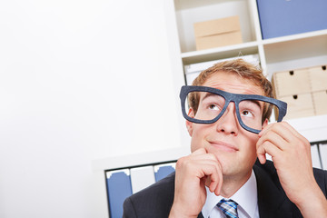 Pensive business man in office with nerd glasses