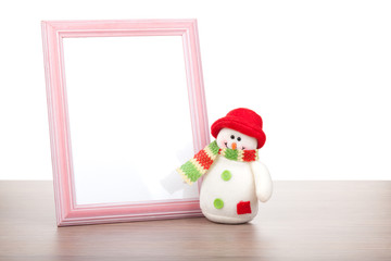 Blank photo frame and christmas snowman on wooden table