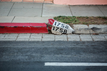 Broken street number on curb curbside