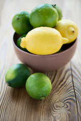 Ripe limes and lemons on a wooden table, shallow depth of field