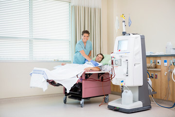 Portrait Of Nurse By Patient Receiving Renal Dialysis