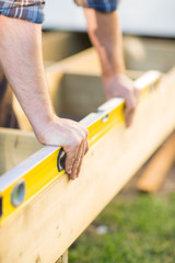 Carpenter's Hands Checking Level Of Wood