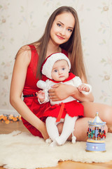 happy mother and cute baby in suit of Santa's helper