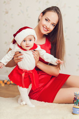 happy mother and cute baby in suit of Santa's helper
