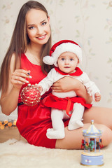 happy mother and cute baby in suit of Santa's helper