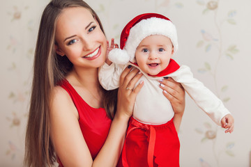 happy mother and cute baby in suit of Santa's helper