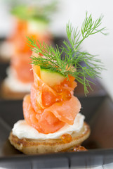 Blini with smoked salmon and sour cream, garnished with dill