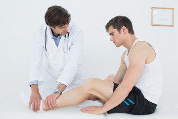 Side view of a young man getting his ankle examined