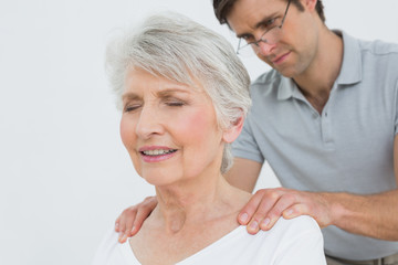 Obraz premium Male physiotherapist massaging a senior woman's neck