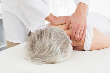 Obraz na płótnie Canvas Physiotherapist massaging a senior woman's back