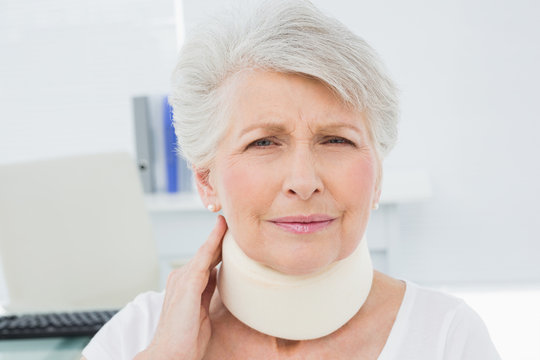 Senior Woman Wearing Cervical Collar In Medical Office