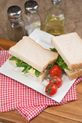 Fototapeta na wymiar Fresh egg and rocket on white sandwich in rustic kitchen setting