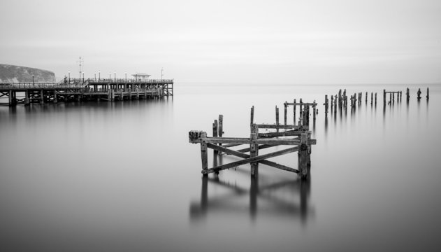 Fine art landscape image of derelict pier in milky long exposure