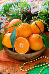 Tangerines in bowl with Christmas decorations