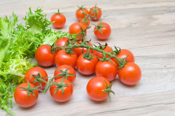 cherry tomatoes and lettuce frieze close-up on a wooden table