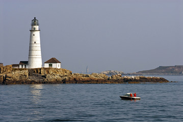 Fishing Near Boston Harbor Lighthouse as Fog Lifts to Display Sunlit Tower