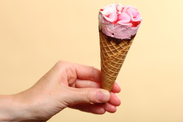 Berry icecream in hand on orange background