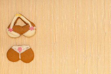 Yellow pink bikini shape gingerbread cake cookie on bamboo mat