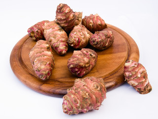  Jerusalem artichoke root on a round board (Helianthus tuberosus