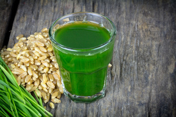 Wheat grass juice on wood background - 59134867