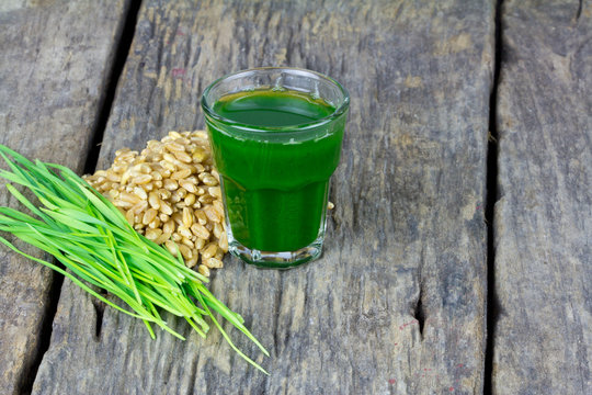 Wheat grass juice on wood background