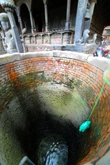 Deurstickers Pulling water containers from well © kagemusha