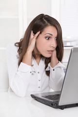 Frau schockiert im Büro vor dem Computer