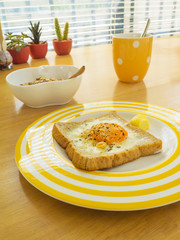 Breakfast . Fried egg on the toast , Muesli yogurt and coffee.