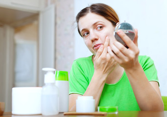 girl stares on  face in mirror