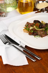 Fried chicken livers on plate on wooden table close-up
