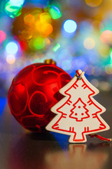 Red ball and white wooden Christmas tree on a background of ligh