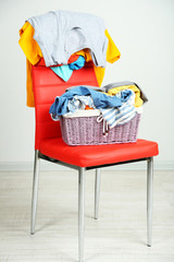 Heap of  clothes on color chair,  on gray background