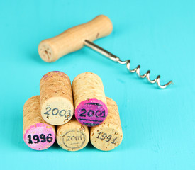 Wine corks with corkscrew on wooden table close-up