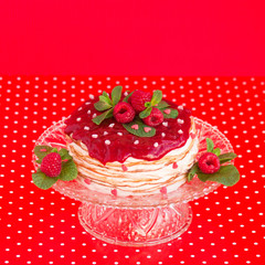 Delicious layered cake topped with raspberry and mint, red