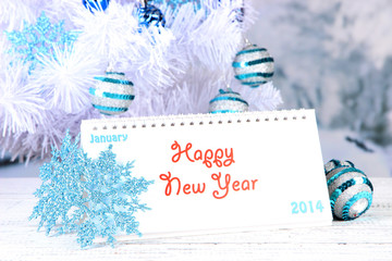 Calendar with New Year decorations on winter background