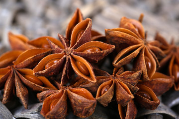 Star anise on wicker mat, on wooden background