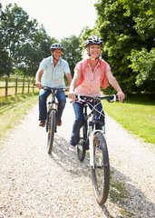 Middle Aged Couple Enjoying Country Cycle Ride Together - obrazy, fototapety, plakaty