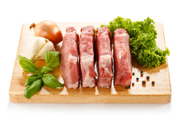 Raw pork on cutting board and vegetables