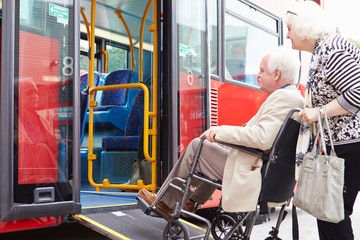 Senior Couple Boarding Bus Using Wheelchair Access Ramp - obrazy, fototapety, plakaty