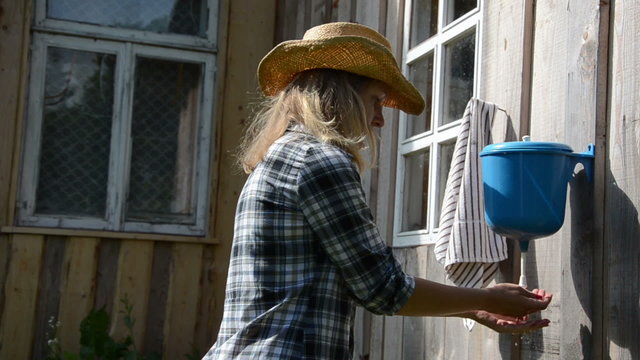 farmer cowgirl woman wash hands under rural plastic washer tool