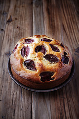 Homemade plum cake with brown sugar on a ceramic plate