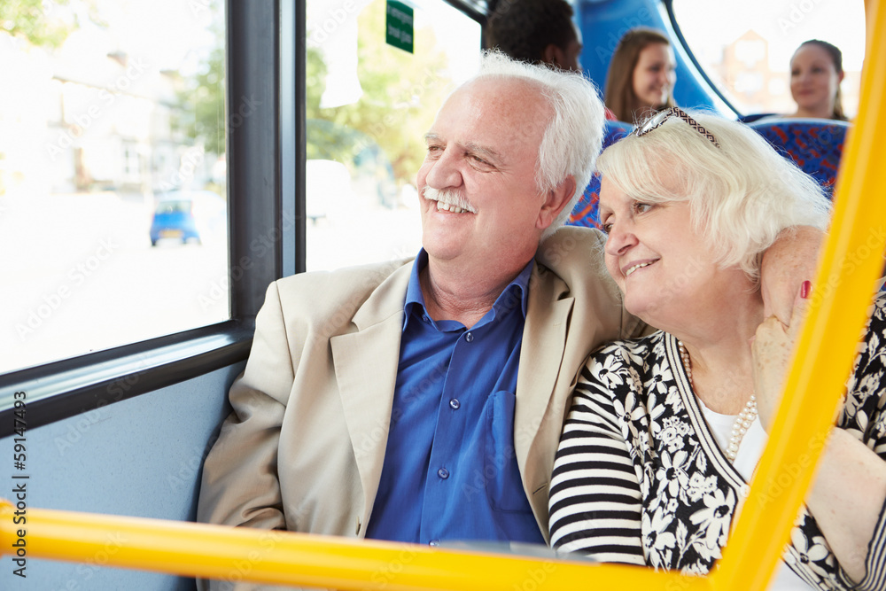 Wall mural senior couple enjoying journey on bus