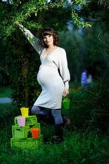 Happy young pregnant woman in the park