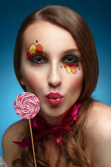 Young model with lollipop. Glossy lips. Fashion makeup.