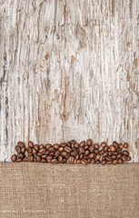 Burlap textile with coffee beans on the old wood